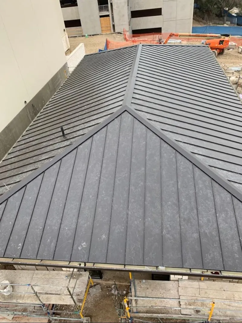 Commercial metal roof construction with crane equipment in Mayflower Village