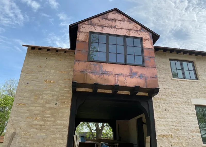 Copper metal panel facade on a stone building for Roof Repair in Mayflower Village